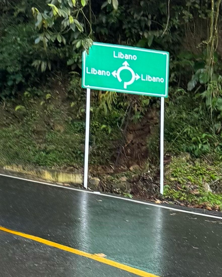 A green roundabout sign in the rain. All three exits point to the same town, Líbano.